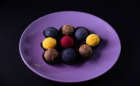 Colored round candies on a plate on a dark background. Flatlay.の写真素材
