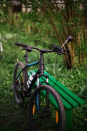 Sports black bike in the park near the benches with blurry background.の写真素材
