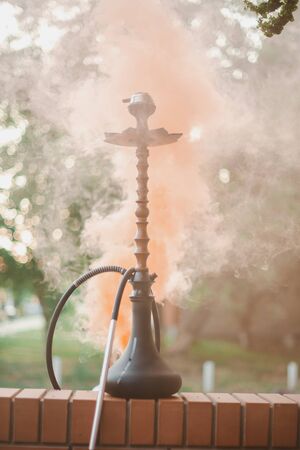 Hookah outdoors on a background of colored smoke.の写真素材