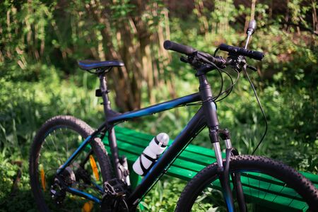 Sports black bike in the park near the benches with blurry background.の写真素材