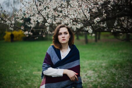 Beautiful young girl is resting and enjoying spring in the spring park.の写真素材