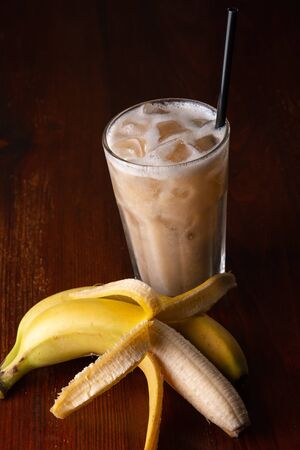 Homemade banana smoothie on wooden background.の写真素材