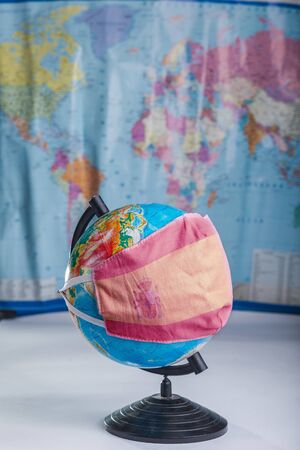 Globe in a medical mask with the image of the flag of Spain. Pandemic concept.の写真素材