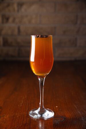 Glass of alcoholic drink with coffee grains on a wooden old table.の写真素材