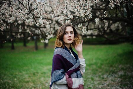 Beautiful young girl is resting and enjoying spring in the spring park.の写真素材