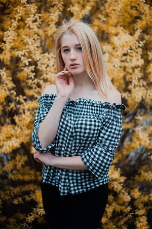 Beautiful young blonde girl on a background of flowering trees.の写真素材