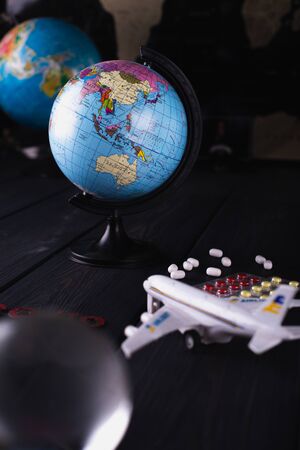 Globe with pills on a dark blurry background. World pandemic concept COVID-19の写真素材