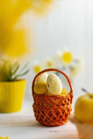 Yellow easter eggs in a basket on a white background.の写真素材