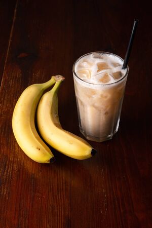 Banana cocktail with ice on wooden background.の写真素材