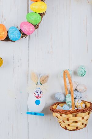 Easter bunny with eggs on a white wooden background.の写真素材