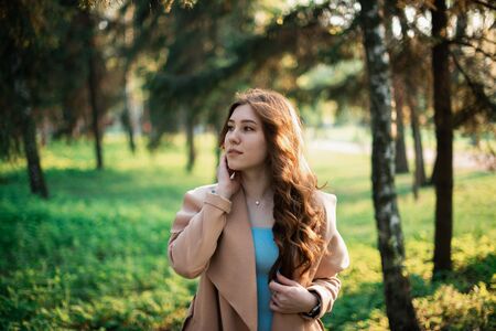 Beautiful young girl in a blue dress in a spring park.の写真素材