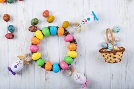 Easter bunny with eggs on a white wooden background.の写真素材
