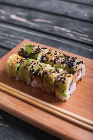 Sushi with salmon on a wooden board on a dark wooden background.の写真素材