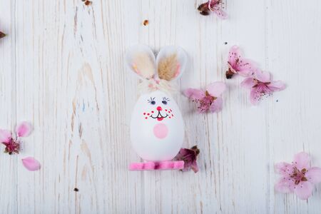 Easter bunny with eggs on a white wooden background.の写真素材