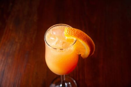 Orange cocktail on a wooden background in a bar.の写真素材