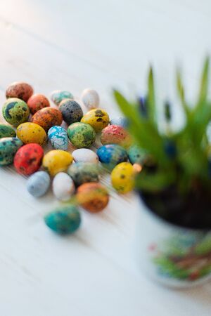 Multi-colored Easter eggs on a white wooden background.の写真素材