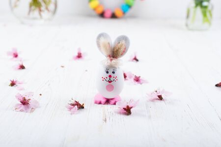 Easter bunny with eggs on a white wooden background.の写真素材