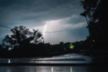 Summer night thunderstorm with powerful lightning in the village.の写真素材