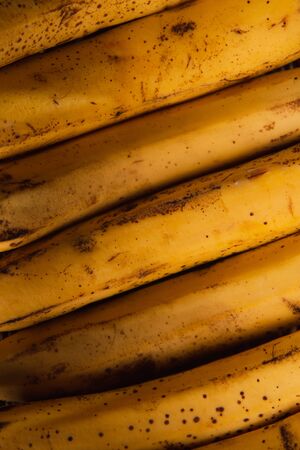 Bananas in a basket on a wooden brown natural background.の写真素材