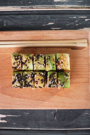 Sushi with salmon on a wooden board on a dark wooden background.の写真素材