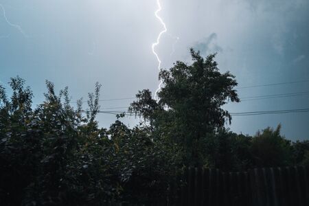Summer night thunderstorm with powerful lightning in the village.