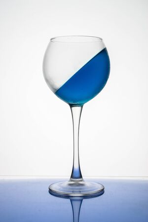 Blue ice drink in a glass is frozen at an angle on a white background.の写真素材