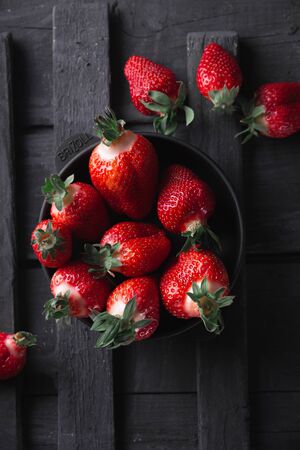 Fresh ripe strawberries on a black wooden background.の写真素材
