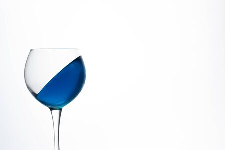 Blue ice drink in a glass is frozen at an angle on a white background.の写真素材