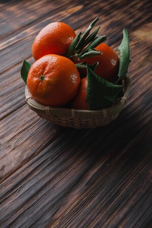 Fresh tangerines with leaves on a wooden old background.の写真素材