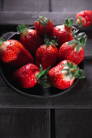 Fresh ripe strawberries on a black wooden background.の写真素材