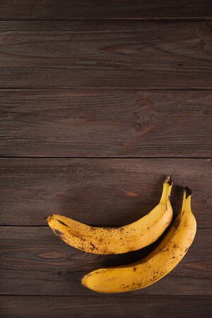 Bananas in a basket on a wooden brown natural background.の写真素材