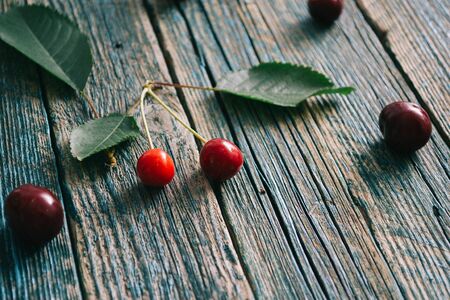 Fresh homemade ripe cherries on a wooden old background. Summer still life.の写真素材