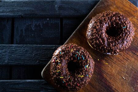 Donuts on a wooden board on a blue concrete background.の写真素材