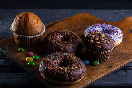 Donuts on a wooden board on a blue concrete background.の写真素材