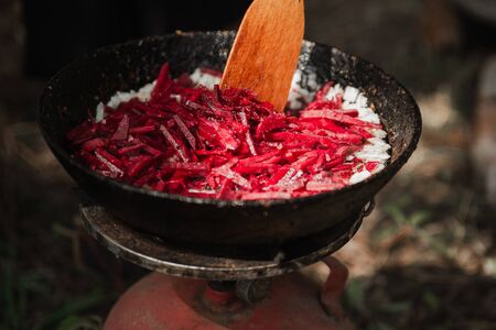Cooking borsch in the fresh air on a fire in nature.の写真素材