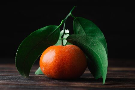 Fresh tangerines with leaves on a wooden old background.の写真素材