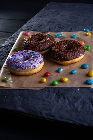 Donuts on a wooden board on a blue concrete background.の写真素材