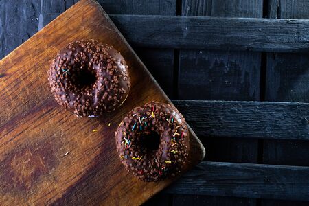 Donuts on a wooden board on a blue concrete background.の写真素材