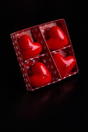 Red scented candles hearts on a black background.の写真素材