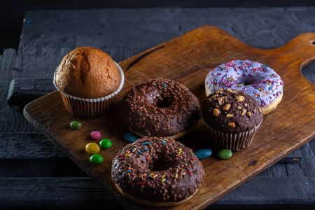 Donuts on a wooden board on a blue concrete background.の写真素材
