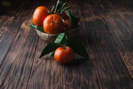 Fresh tangerines with leaves on a wooden old background.の写真素材