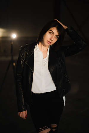 Girl in a leather jacket on an old abandoned construction site.の写真素材