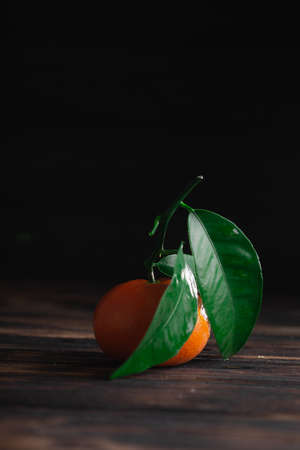 Fresh tangerines with leaves on a wooden old background.の写真素材