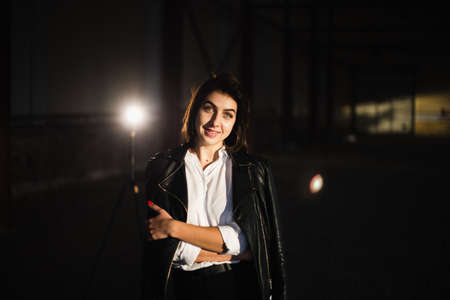 Girl in a leather jacket on an old abandoned construction site.