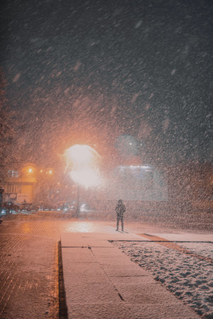 The first snow in the night city with a blurred background in the light of lanternsの写真素材