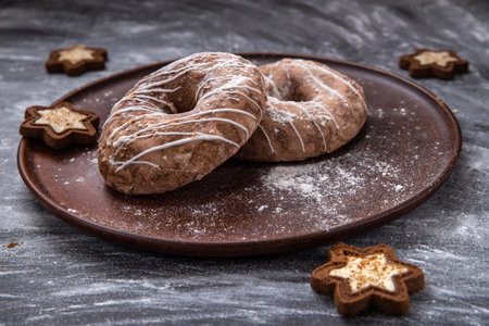 Homemade craft gingerbread cookies sprinkled with powdered sugar on a gray backgroundの写真素材