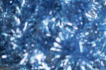 Christmas lights of christmas tinsel on background. Out of focus, blues. Festive atmosphere of lights in the night.の写真素材
