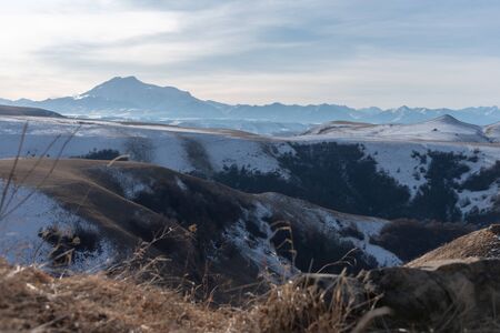 View of the Caucasus Range and Mount Elbrus. The mountains are stark on the horizon in a haze of blue. Background for travelers.の写真素材