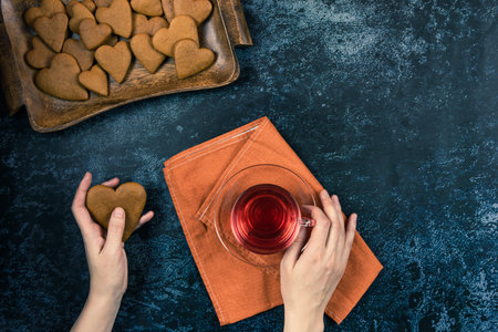 Homemade baked ginger cookies lie on a wooden board. Shape in the form of hearts. A loved breakfast...