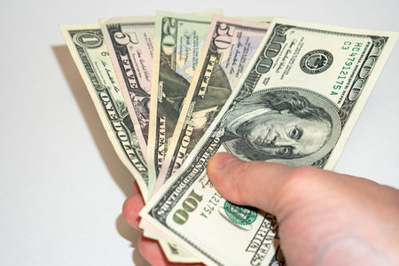 U.S. dollars in hand on a white background, american dollars